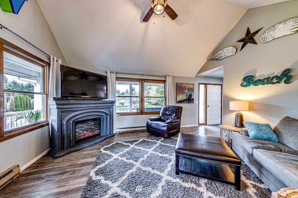 155 Taylor Cutoff Road Sequim, WA 98382 - Photo 7 of 37 a living room with furniture flat screen tv and a fireplace