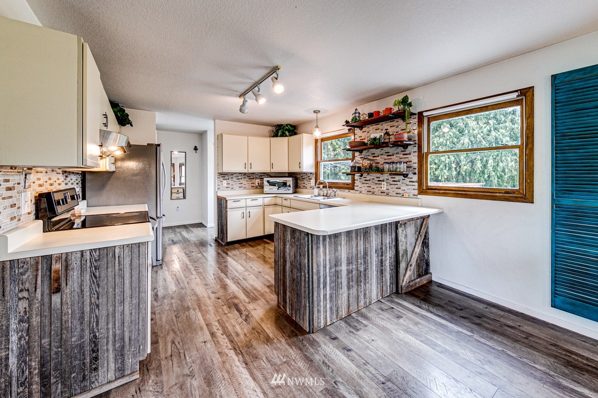 155 Taylor Cutoff Road Sequim, WA 98382 - Photo 9 of 37 a kitchen with a stove a refrigerator and wooden floor