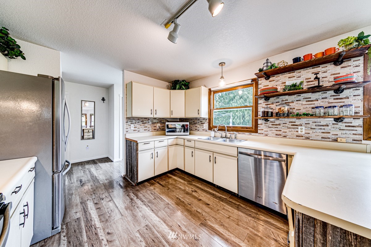 155 Taylor Cutoff Road Sequim, WA 98382 - Photo 10 of 37 a kitchen with granite countertop white cabinets a sink and white appliances