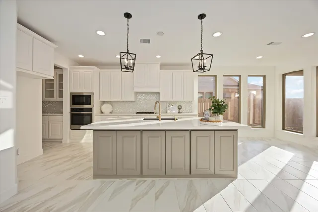 a large kitchen with kitchen island a sink stainless steel appliances and cabinets