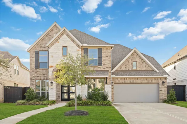 a front view of a house with a yard and garage