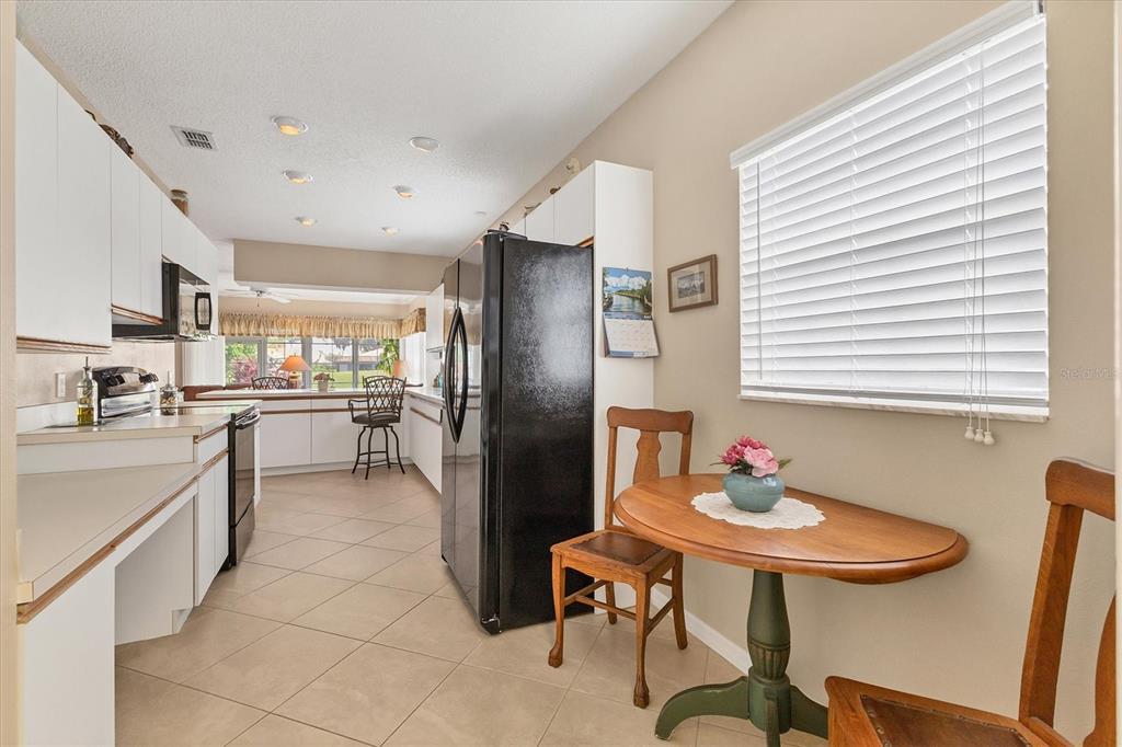 1412 Colony Place Venice, FL 34292 - Photo 14 of 55 a kitchen with stainless steel appliances kitchen island granite countertop a sink and cabinets