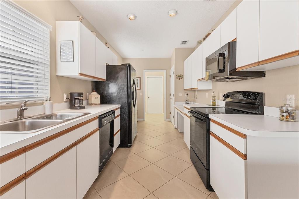 1412 Colony Place Venice, FL 34292 - Photo 17 of 55 a kitchen with stainless steel appliances granite countertop a sink a stove a refrigerator cabinets and a window