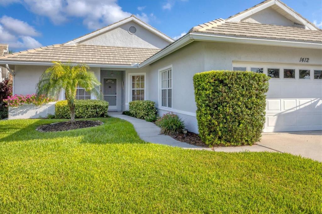 1412 Colony Place Venice, FL 34292 - Photo 2 of 55 a front view of a house with garden