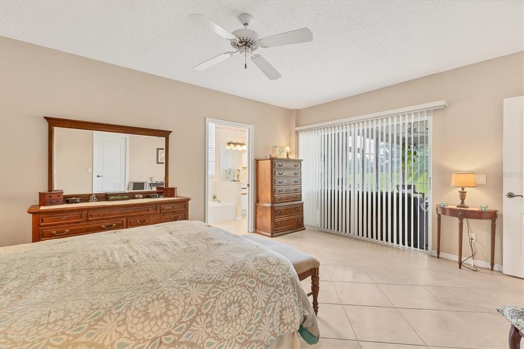 1412 Colony Place Venice, FL 34292 - Photo 21 of 55 a spacious bedroom with a large bed and a chandelier