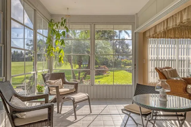 a living room with patio furniture and a floor to ceiling window
