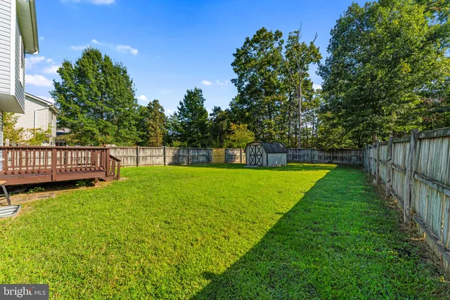 a view of garden with a slide and a bench