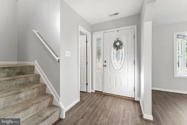 a view of a hallway with wooden floor and entryway