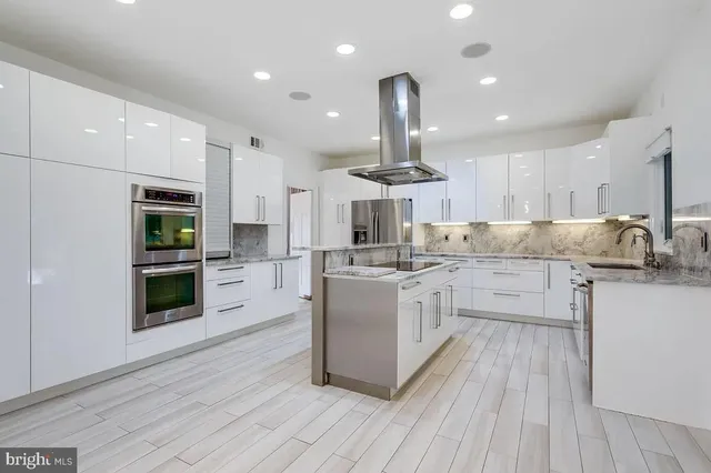 a kitchen with stainless steel appliances granite countertop a refrigerator a stove a sink and a oven