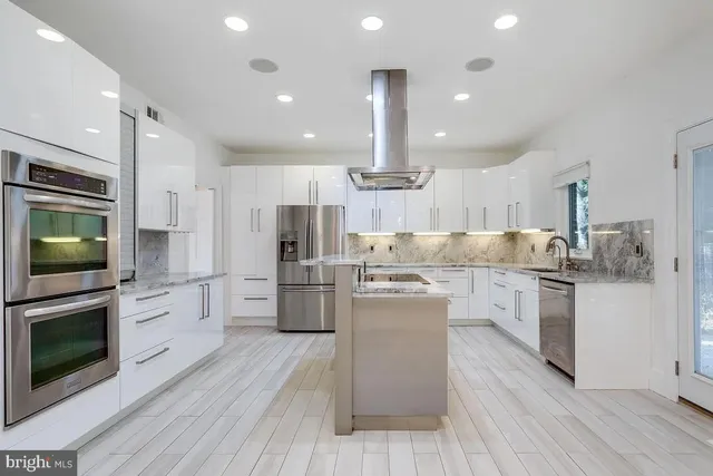 a kitchen with white cabinets stainless steel appliances and kitchen island