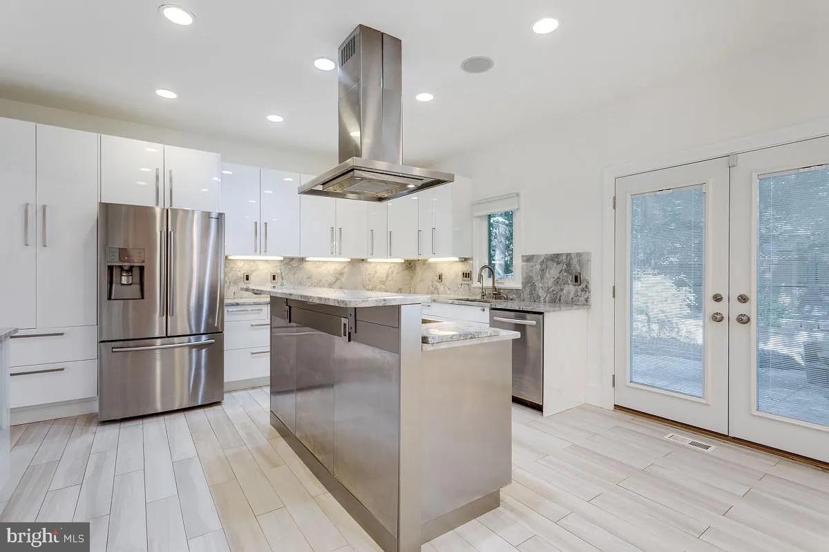 4611 Charleston Terrace Northwest Washington, DC 20007 - Photo 14 of 55 a kitchen with kitchen island a refrigerator a stove a oven and a sink with wooden floor