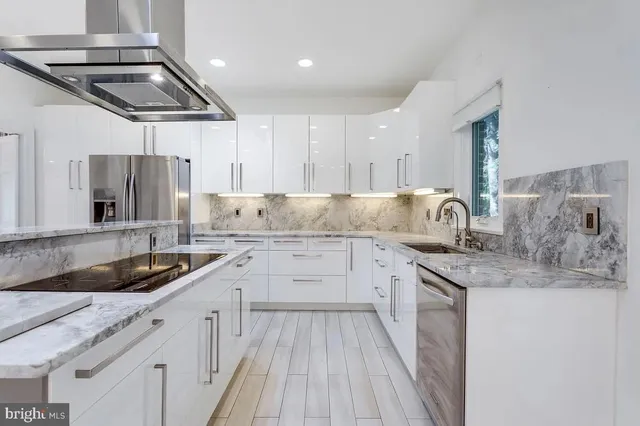 a kitchen that has a sink a stove and cabinets