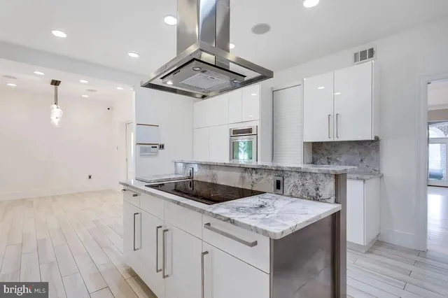 a kitchen that has a sink a stove and a wooden floor