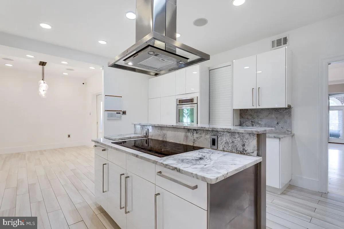 4611 Charleston Terrace Northwest Washington, DC 20007 - Photo 16 of 55 a kitchen that has a sink a stove and a wooden floor