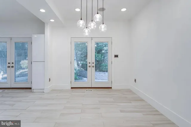 a view of a livingroom with wooden floor a chandelier and windows