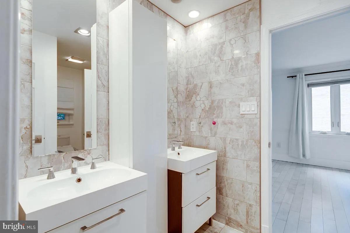 4611 Charleston Terrace Northwest Washington, DC 20007 - Photo 26 of 55 a bathroom with a sink mirror and shower