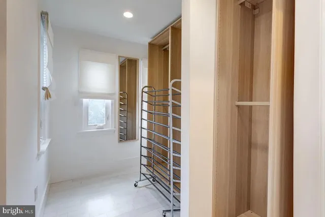a view of an empty room with wooden floor and windows