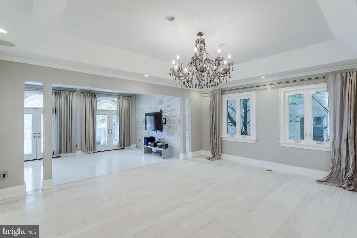 4611 Charleston Terrace Northwest Washington, DC 20007 - Photo 7 of 55 an empty room with chandelier and windows