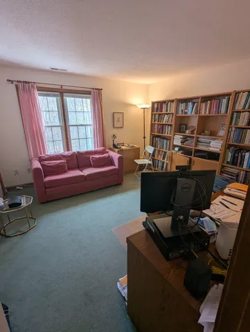 a living room with furniture a flat screen tv and a window