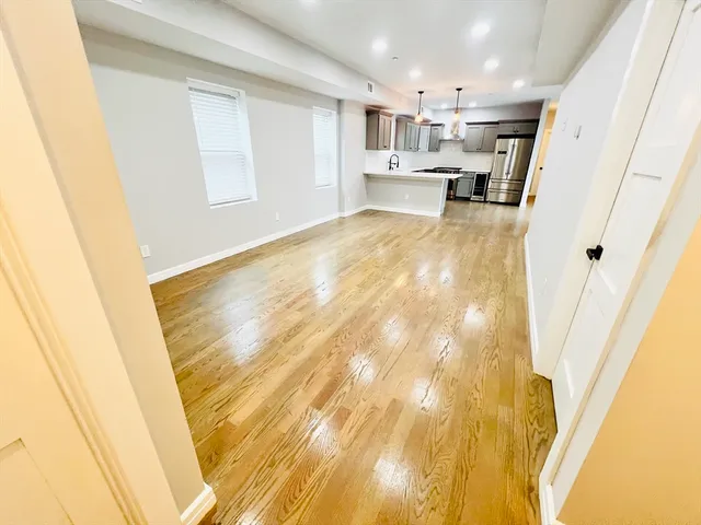 a view of empty room with wooden floor