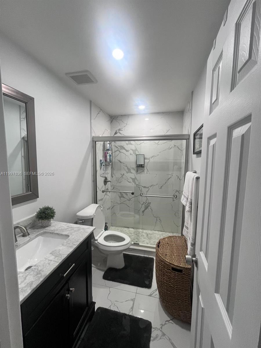 4533 Southwest 143rd Place Miami, FL 33175 - Photo 6 of 12 a bathroom with a granite countertop sink toilet and shower
