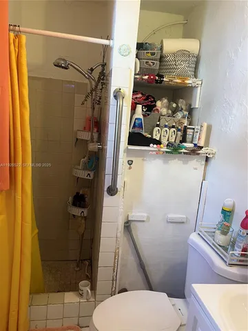 a bathroom with a sink a toilet and shower curtain