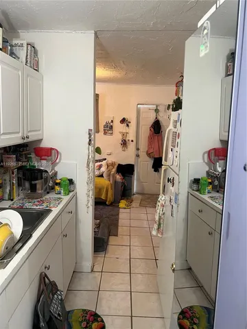 a view of a kitchen with fridge and workspace