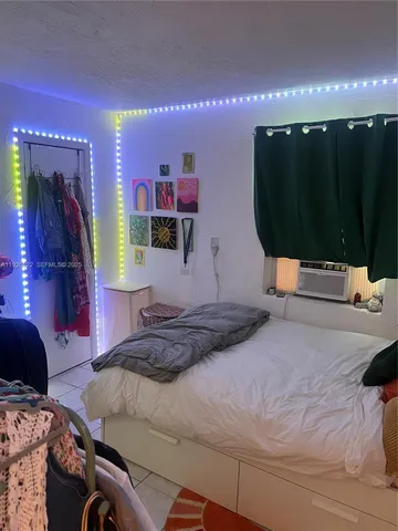 a bedroom with a bed a mirror and lamp