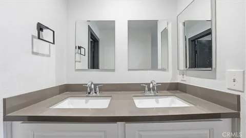 a bathroom with double vanity sinks and a mirror