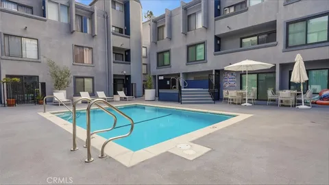a view of a building with a swimming pool and sitting area