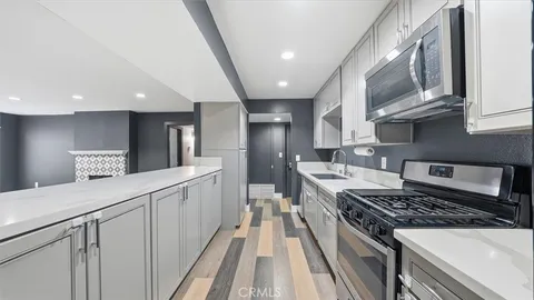 a kitchen with stainless steel appliances a sink stove and cabinets