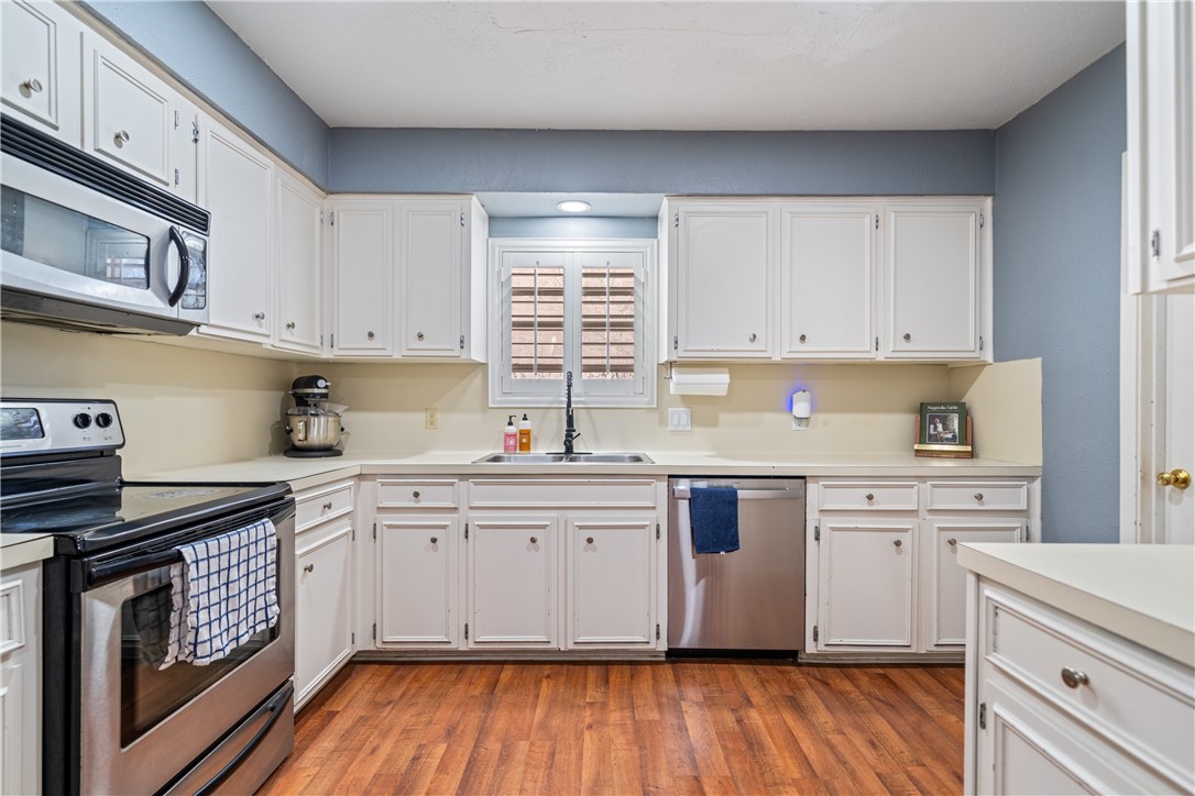 2217 Post Oak Drive Portland, TX 78374 - Photo 11 of 39 a kitchen with cabinets wooden floor and stainless steel appliances