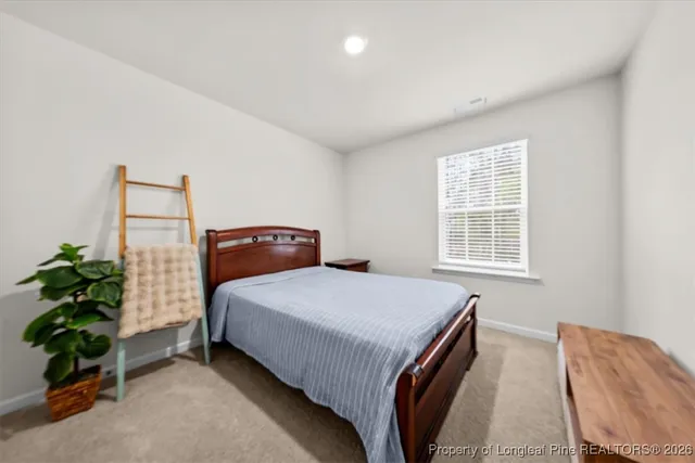 a bedroom with a bed and a potted plant