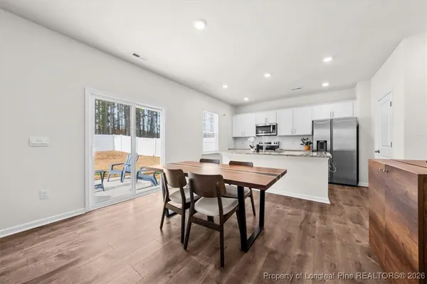 a kitchen with a dining table chairs refrigerator and cabinets