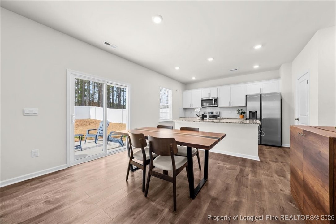 917 Ocean Court Carthage, NC 28327 - Photo 8 of 32 a kitchen with a dining table chairs refrigerator and cabinets