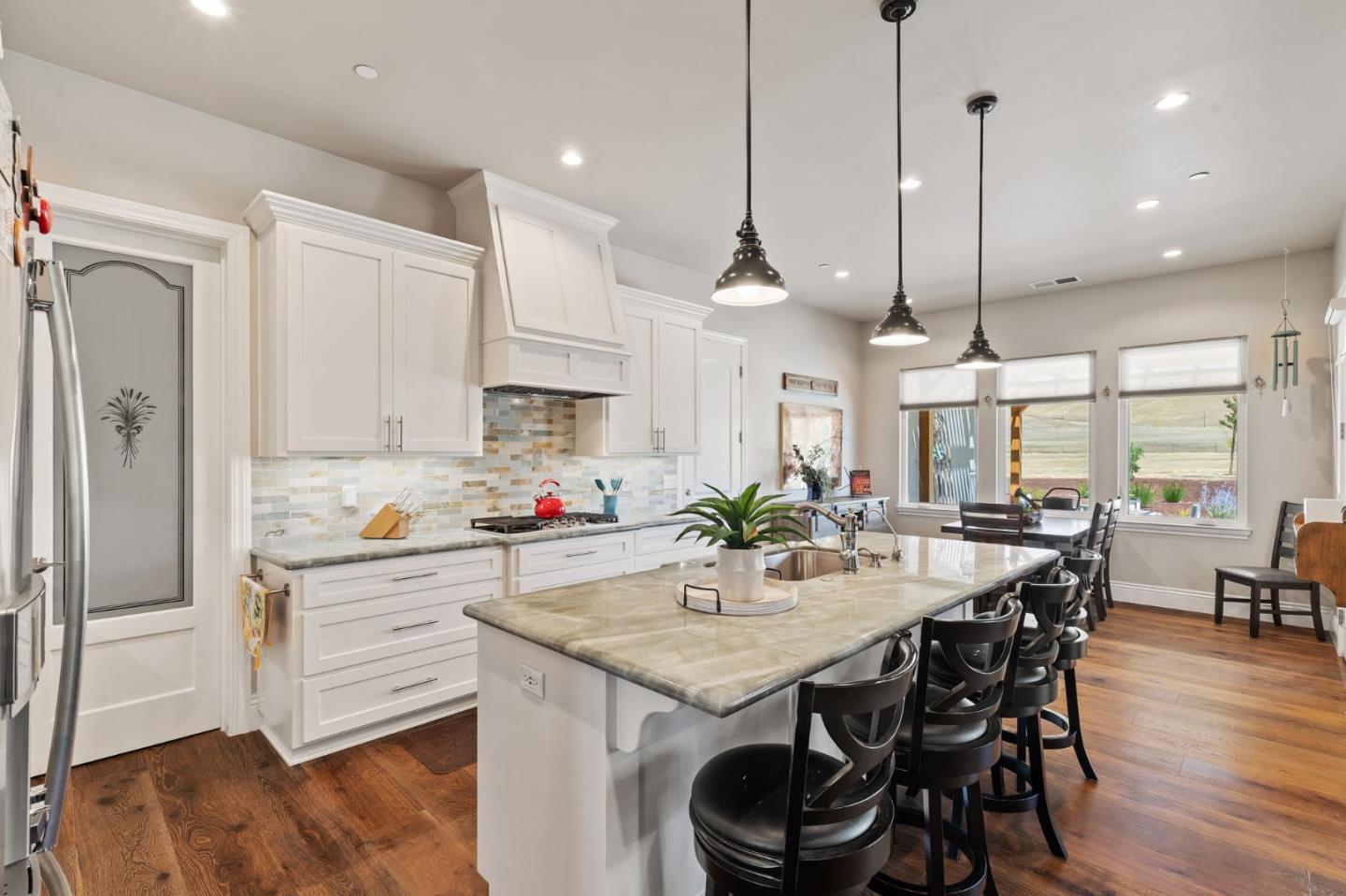 7251 Diablo Hills Road Tres Pinos, CA 95075 - Photo 11 of 60 a kitchen with stainless steel appliances kitchen island granite countertop a table chairs stove and refrigerator