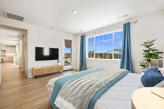 a bedroom with a large bed and a potted plant