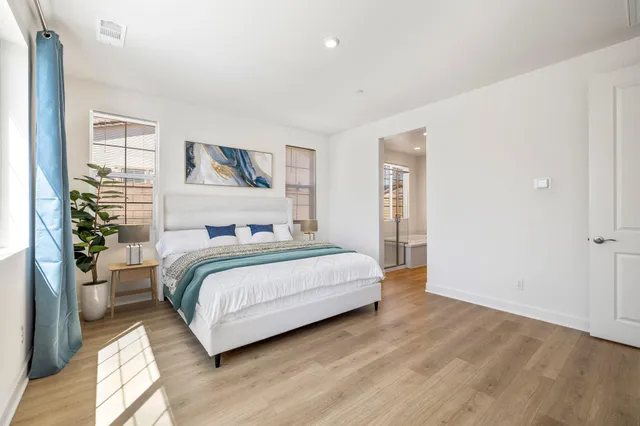 a bathroom with a double vanity sink a large mirror and a bathtub