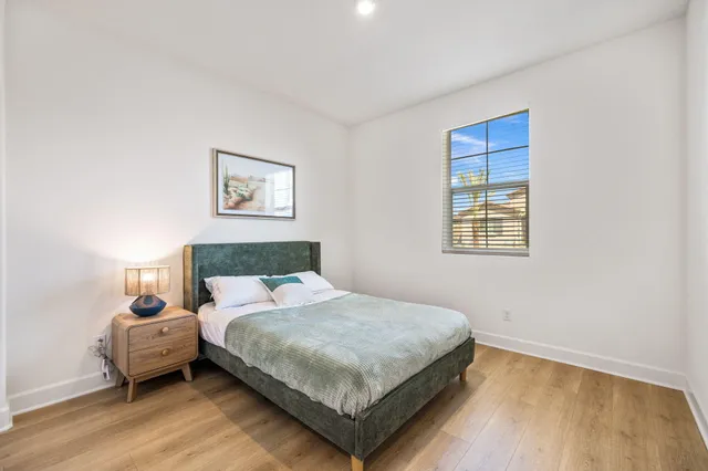 a bedroom with a large bed and wooden floor