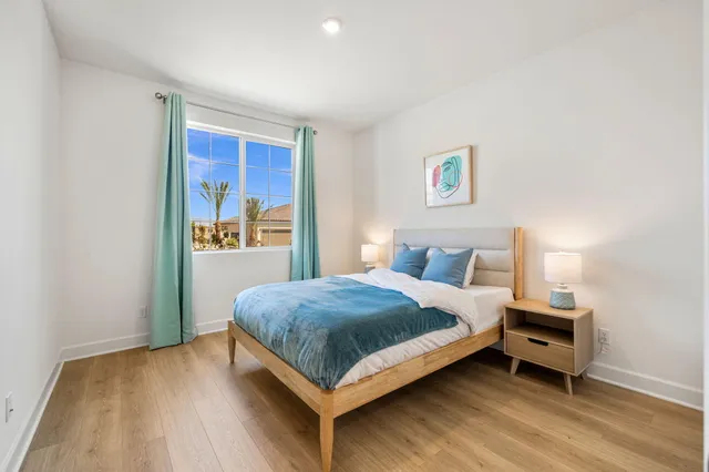 a bedroom with a bed and wooden floor