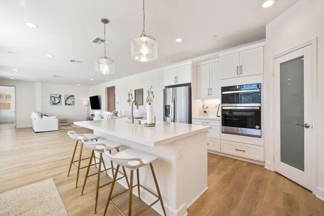 a large kitchen with kitchen island a large counter top space appliances and cabinets