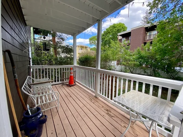 a view of balcony with wooden floor and seating space
