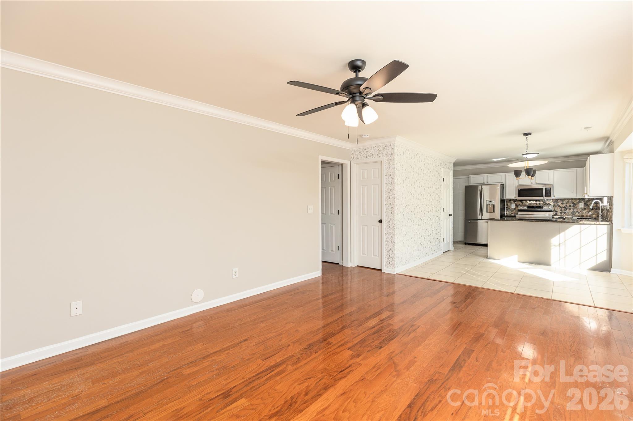 9724 Steele Meadow Road Charlotte, NC 28273 - Photo 11 of 38 a view of a room with wooden floor and a ceiling fan