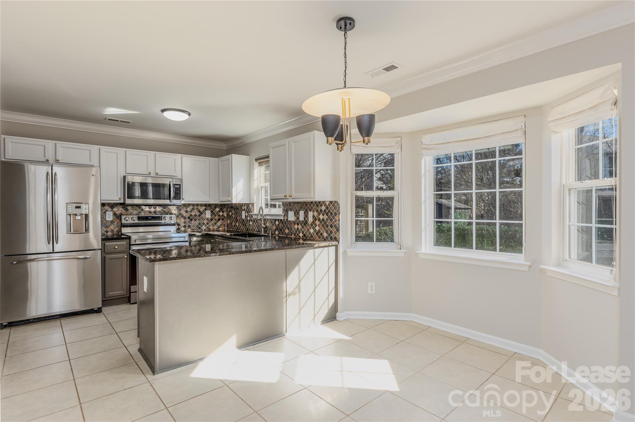 9724 Steele Meadow Road Charlotte, NC 28273 - Photo 14 of 38 a kitchen with stainless steel appliances granite countertop a refrigerator a oven a sink a stove and white cabinets