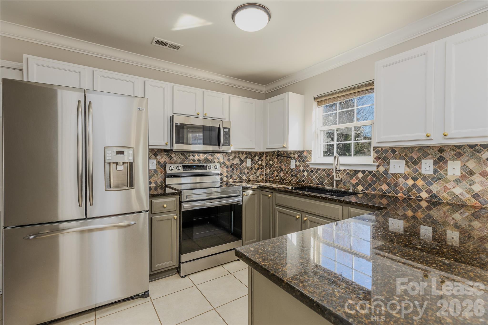 9724 Steele Meadow Road Charlotte, NC 28273 - Photo 16 of 38 a kitchen with granite countertop a refrigerator stove and sink