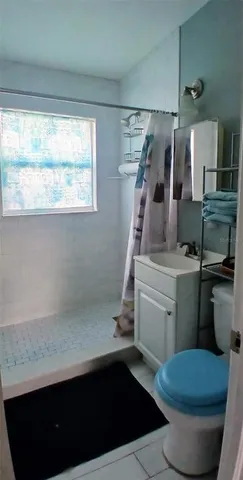 a bathroom with a sink a toilet and a window
