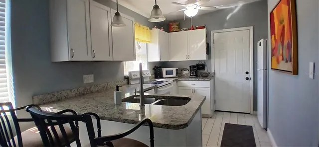 a kitchen with stainless steel appliances granite countertop a sink refrigerator and cabinets