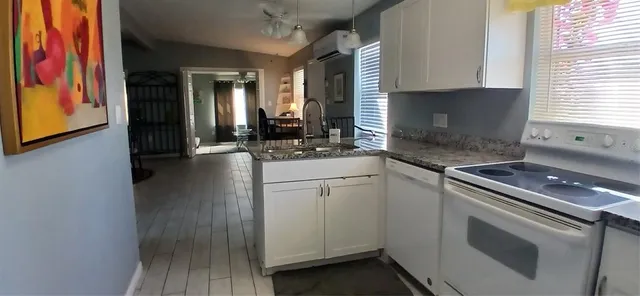 a kitchen with granite countertop white cabinets and white appliances