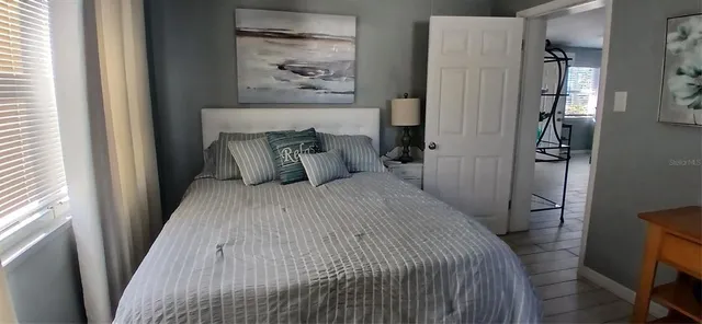 a bedroom with a bed and painting on the wall