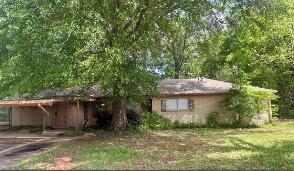 a front view of a house with a garden and tree